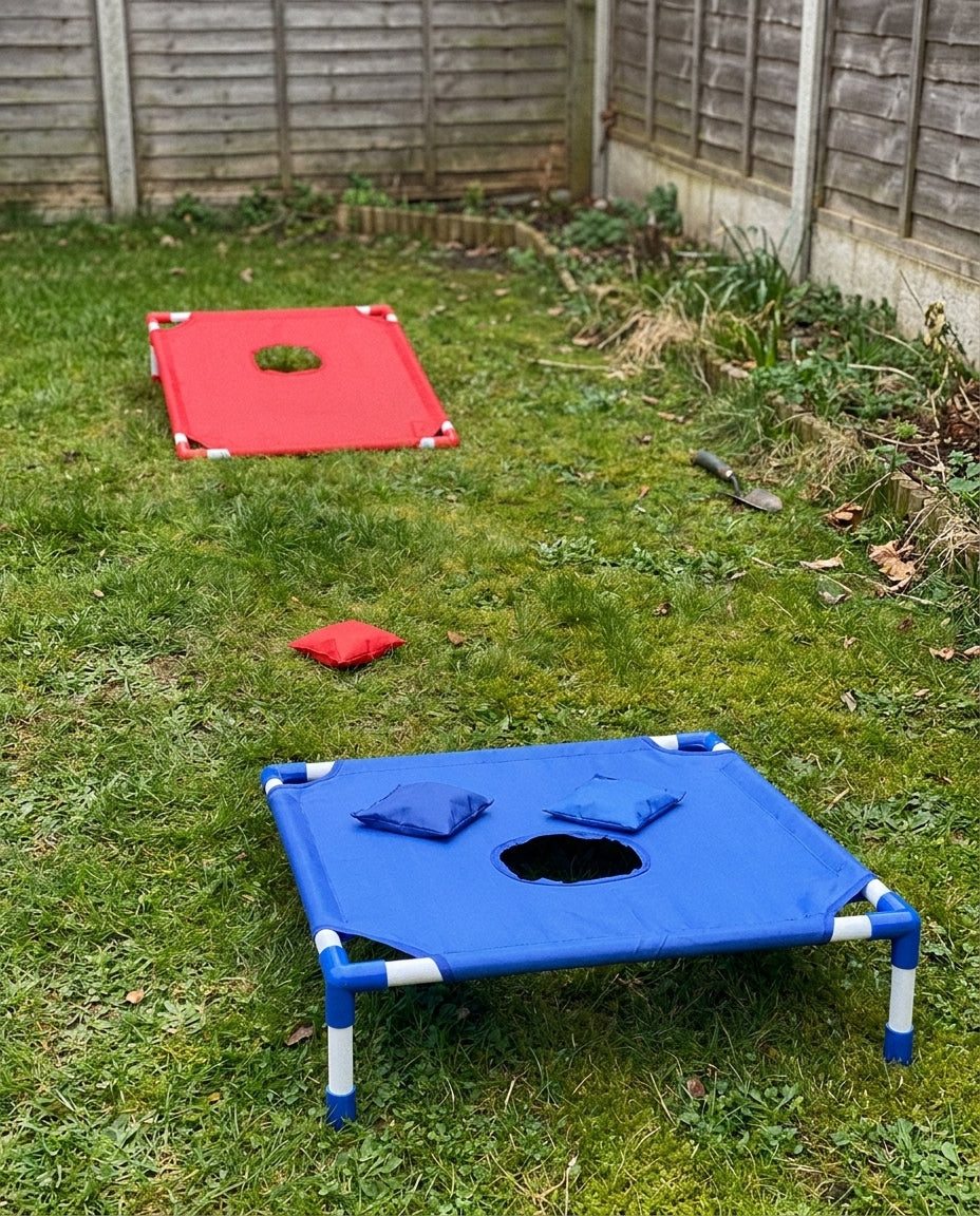 Children playing cornhole in the summer — pulling the board along the beach by its carry rope