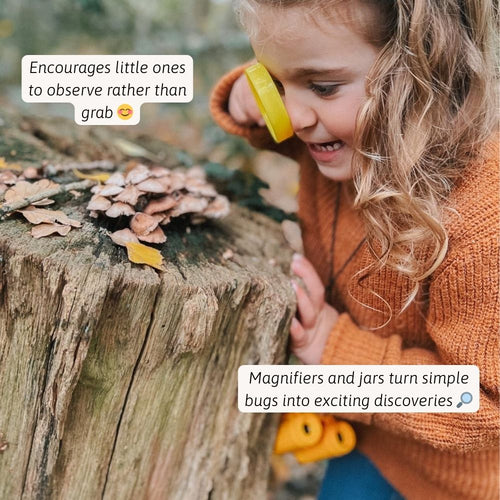 Child using a magnifying glass to examine nature on a wooden log 