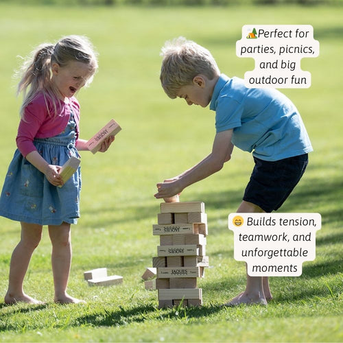 Two children playing with a stack of wooden blocks on grass 