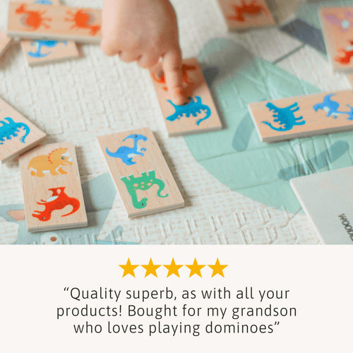 Children playing with wooden dominoes featuring colourful animal illustrations on a light surface. 