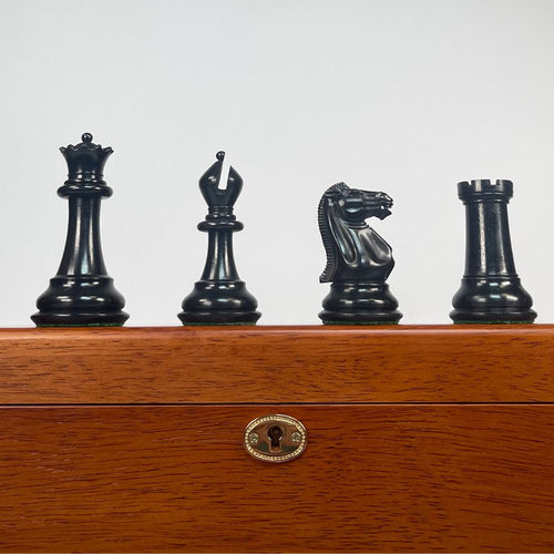 Set of black chess pieces on a wooden chessboard with a white background 