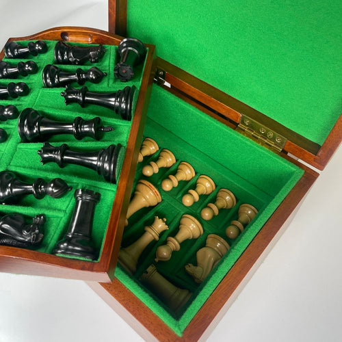 Chess set with black and white pieces in a wooden box on a green felt interior 