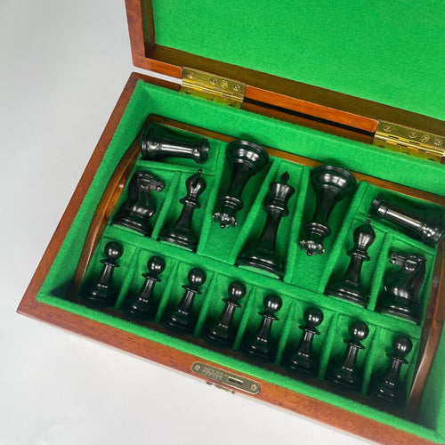 Chess pieces set in a wooden box with green felt interior 
