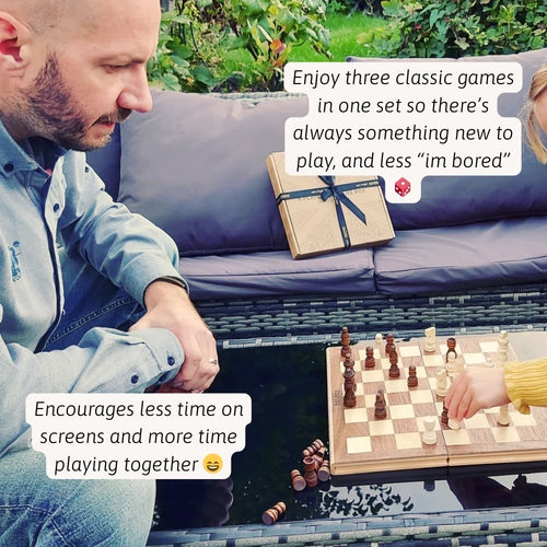 A father and child playing chess together on a wooden folding chess set during family game time. 