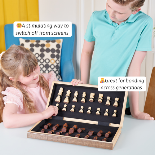 A child and an adult playing chess with a wooden folding chess set on a table, with the board open and chess pieces set up. 