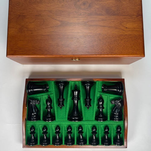 Wooden chess set with black pieces on a green felt background 