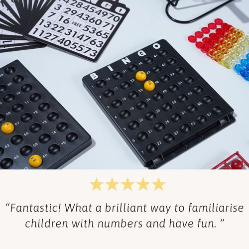 Black bingo board with yellow markers on a white surface, surrounded by cards and coloured markers. 