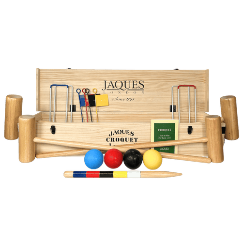 Croquet set with wooden mallets, balls, and flags on a green background 