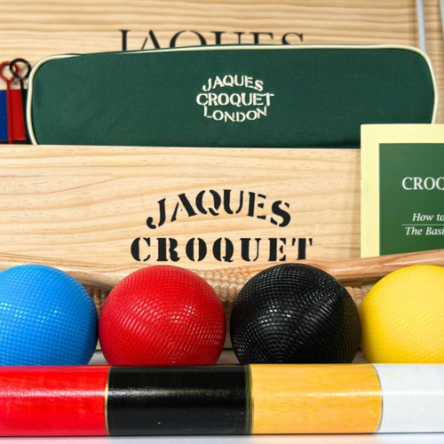 Croquet set with balls and mallets in front of a Jaques Croquet London case.  