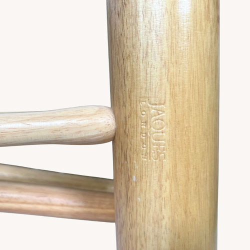 Close-up of wooden chair legs with 'Jacobsen' branding on a white background  