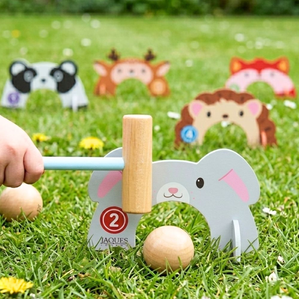 Children's croquet set with animal figures on a grassy field  