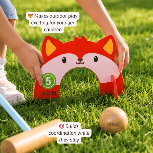 Children playing with a red fox-shaped croquet mallet and ball on grass  