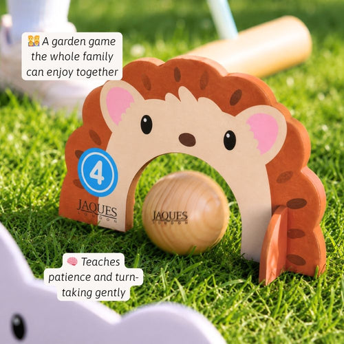 Wooden hedgehog toy with a ball on grass, featuring Jaques of London branding.  