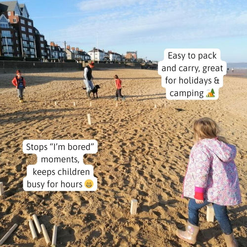 Family playing wooden Kubb garden game on grass outdoors 