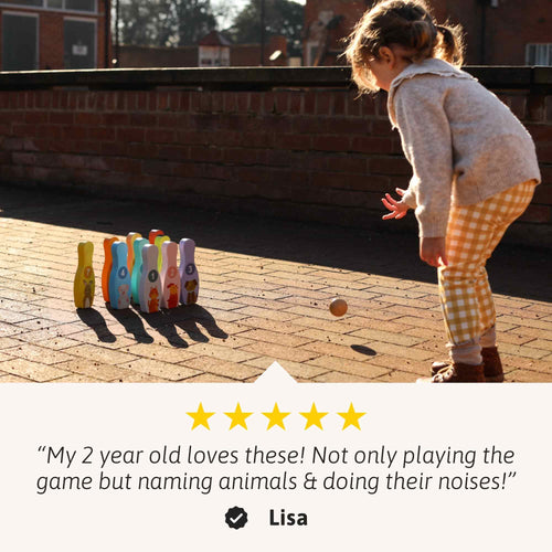 Child playing with colorful animal-shaped pins on a brick surface 