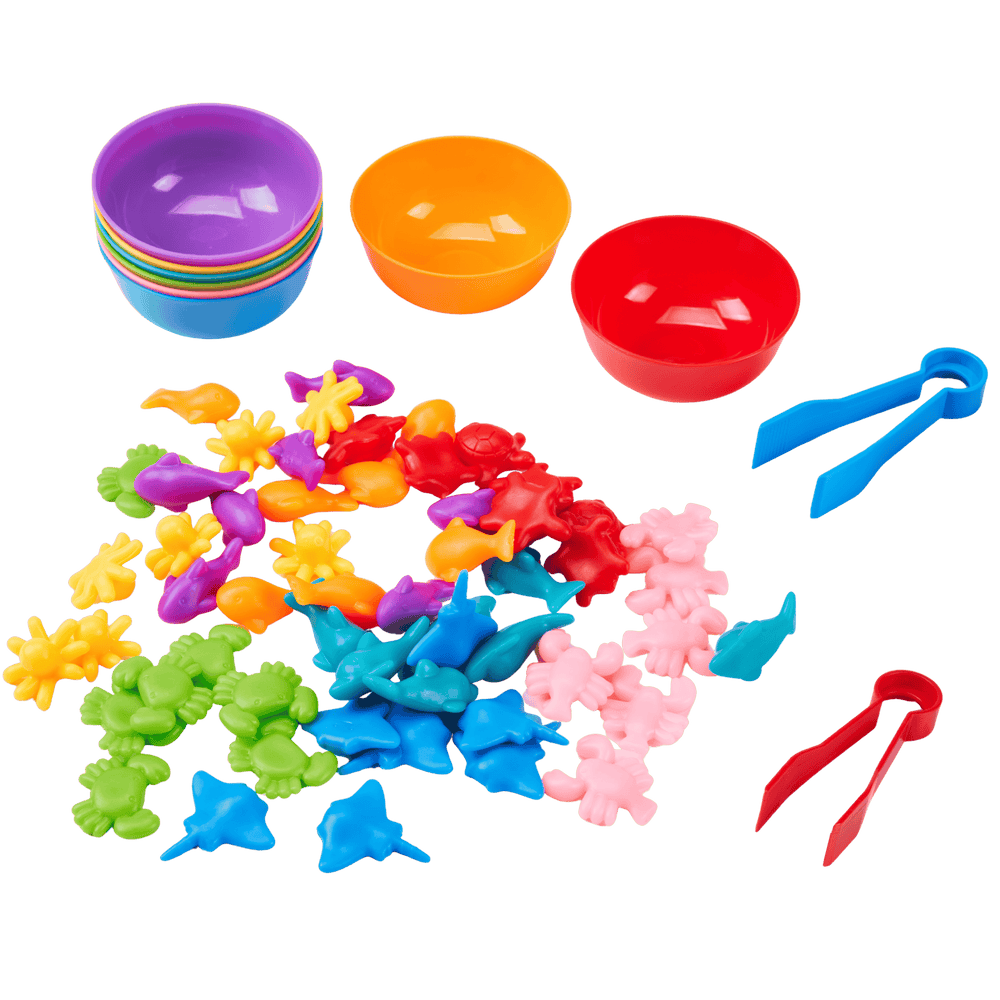 Colourful plastic toys including bowls, tongs, and sea creature figures on a clear background 