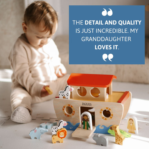 Child playing with a wooden toy boat and animal figures on a light surface. 