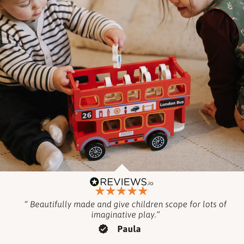 Two children sitting on the floor playing with a red wooden London bus toy, accompanied by a customer review praising its quality and imaginative play value. 