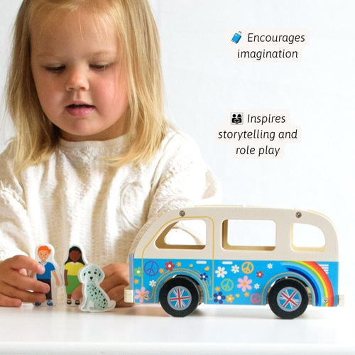 A young child in a white sweater plays with a colorful wooden toy van and small wooden figures on a white surface. Text on the image says it encourages imagination and inspires storytelling and role play. 