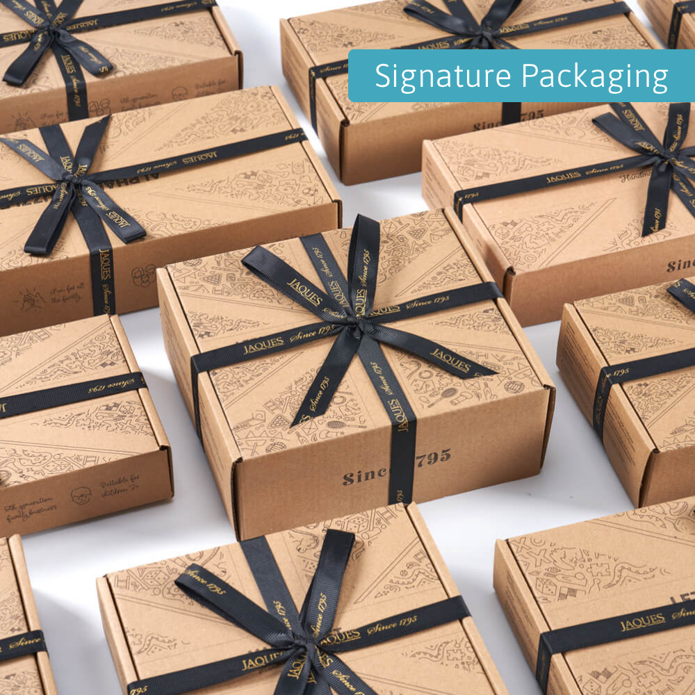 Multiple Jaques London gift boxes arranged neatly, each tied with black branded ribbon and labelled “Signature Packaging” 
