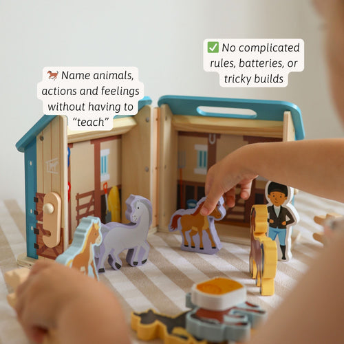 Child’s hands playing with wooden horse stable set, placing horse figures inside the open stable with fences and accessories. Text mentions no complicated rules or batteries. 