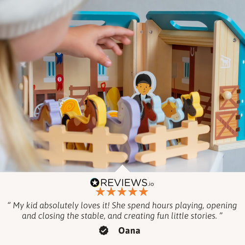 Hands arranging horses and fences around the wooden stable playset, with a review quote overlay about kids loving the toy. 