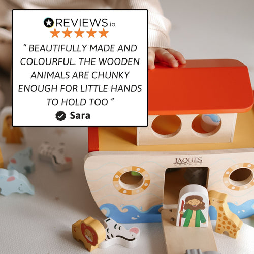 Wooden Noah’s Ark toy with red roof and animal figures displayed on a neutral background, featuring a customer review quote overlay in the top left corner 