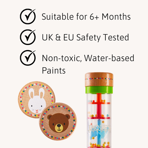 Rain sound maker shown with wooden animal-end caps beside icons highlighting age suitability, UK/EU safety testing, and non-toxic water-based paints 