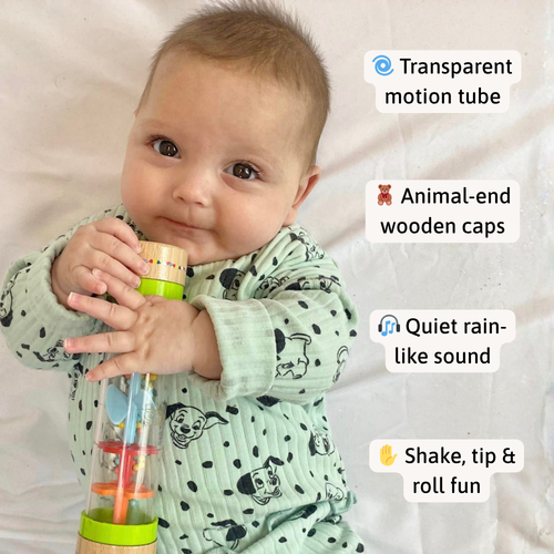 Baby lying on a soft surface holding the rain sound maker, with callouts highlighting the transparent tube, wooden animal caps, quiet rain sound, and sensory play features 