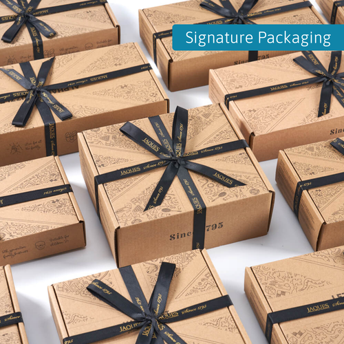 Multiple Jaques London gift boxes arranged neatly, each tied with black branded ribbon and labelled “Signature Packaging” 
