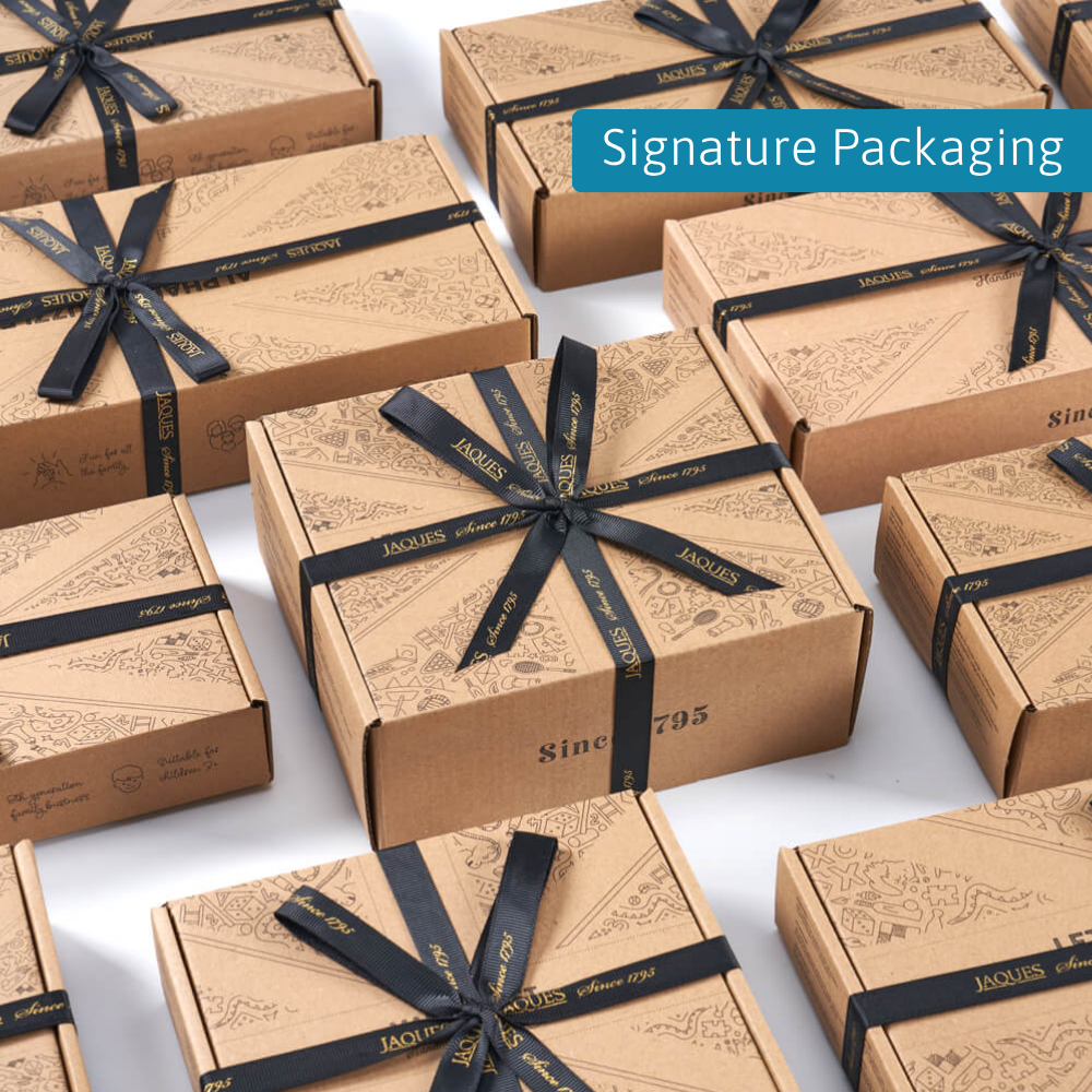 Multiple Jaques London gift boxes arranged neatly with black ribbon, labelled “Signature Packaging” 