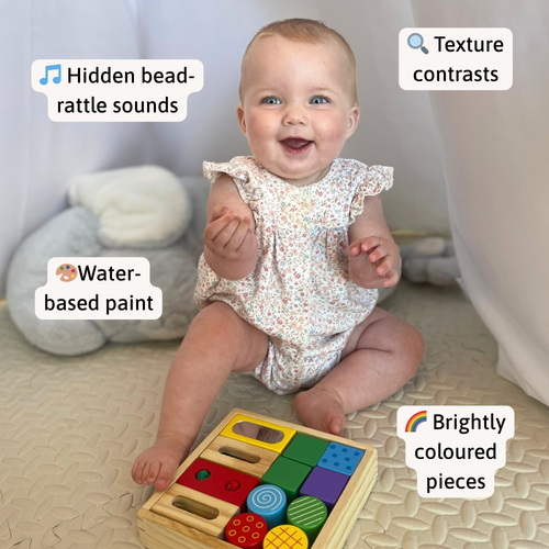 Baby sitting with the wooden sensory block set, with callouts for bead-rattle sounds, texture contrasts, water-based paint, and brightly coloured pieces 