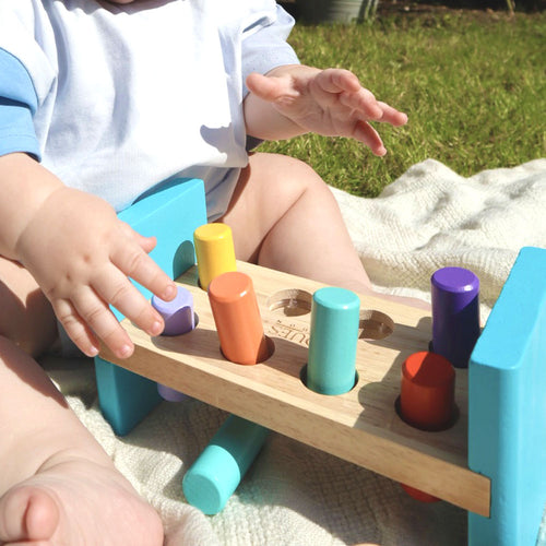 Baby playing with wooden hammering bench 