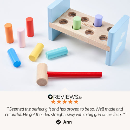 Colourful wooden toy with pegs and a mallet on a light blue background, featuring a customer review.