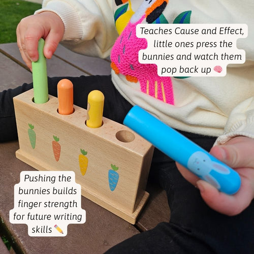 A child using the wooden hammer to tap the bunnies and watch them pop up 