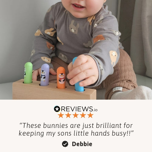 Hands-on play as a toddler pushes the colourful bunnies down 