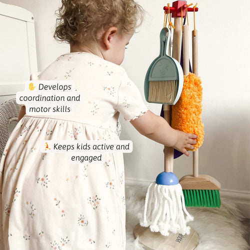 Child playing with toy broom and dustpan set, promoting coordination and motor skills.