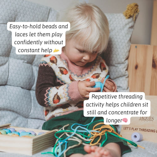 A child threading colourful wooden beads onto a lace to practise coordination 