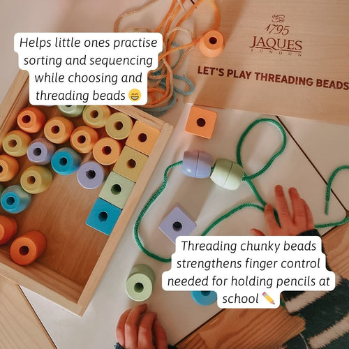Close-up of beads being threaded as a child builds their own colourful pattern 
