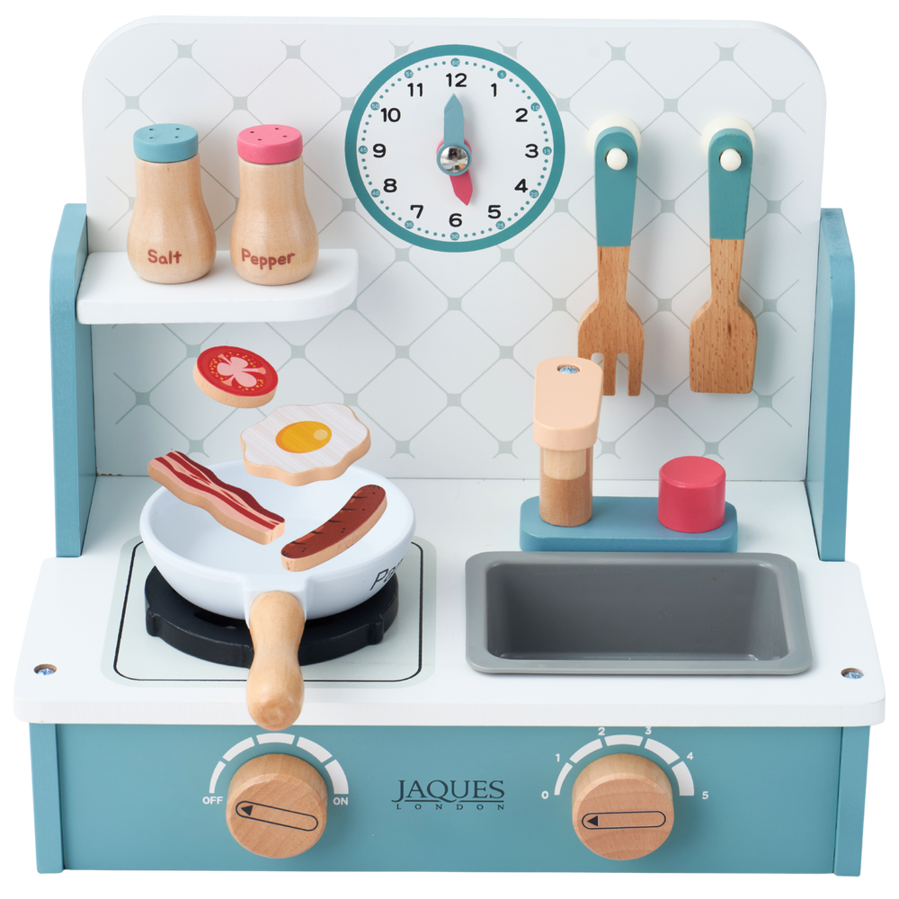 Jaques wooden toy play kitchen with a light blue and white stove, toy utensils, salt and pepper shakers, a clock, and cooking accessories, shown on a white background. 