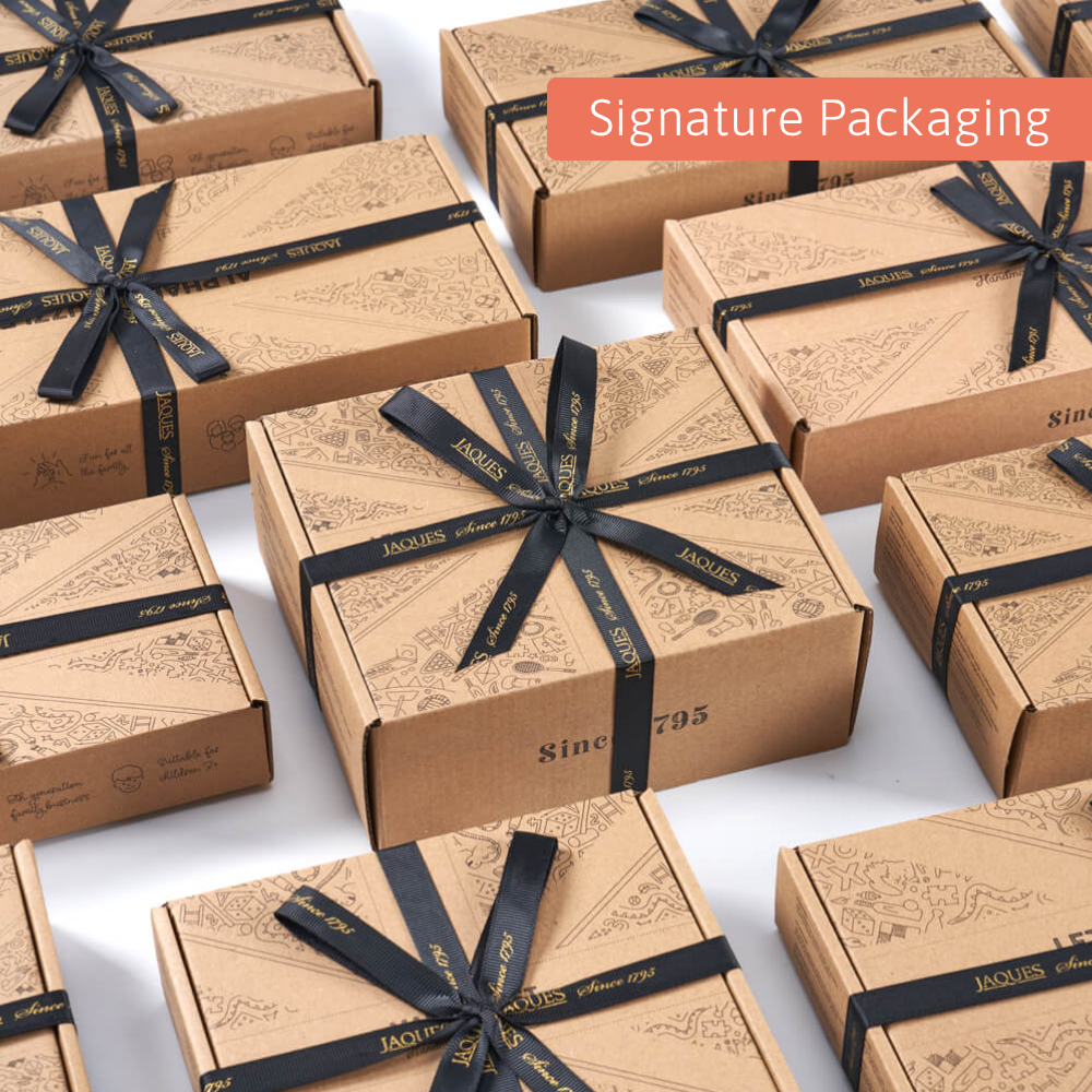 A display of Jaques of London kraft gift boxes tied with black branded ribbon, arranged neatly to show the brand’s signature packaging style. 