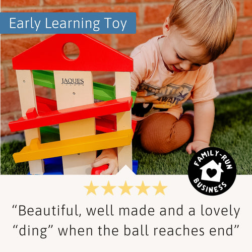 Toddler playing with Jaques of London colourful wooden ramp toy – encouraging early learning, coordination, and sensory play development. [filll]

