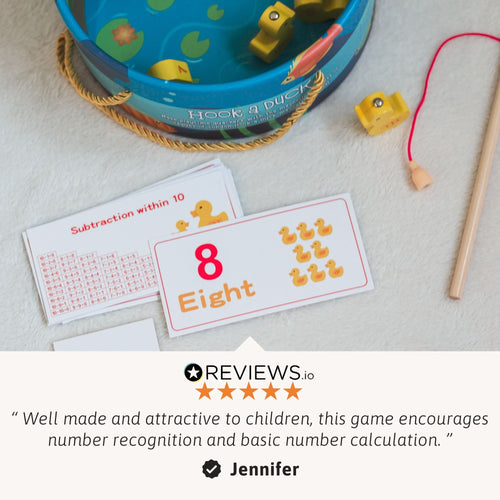 Close-up of the duck fishing game set with number cards and wooden fishing rod displayed beside the pond, with a customer review quote underneath 