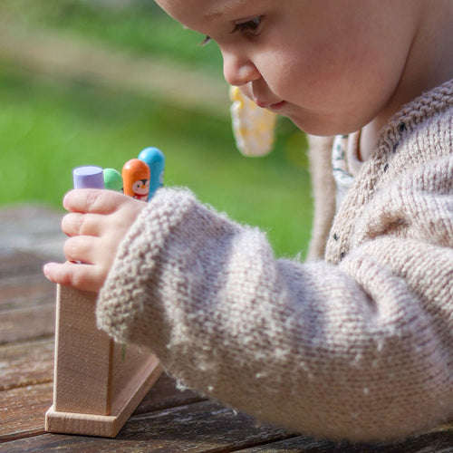 Child playing with colorful wooden toys outdoors 