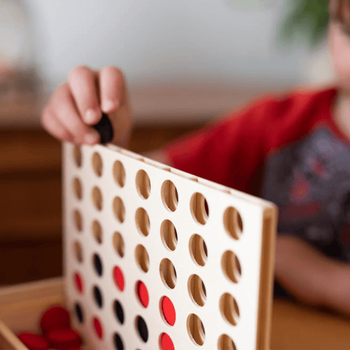  Close up of boy putting black counter into the wooden board