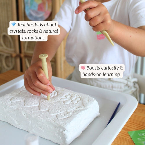 Child using tools to work with a white material on a tray, likely for educational purposes. 