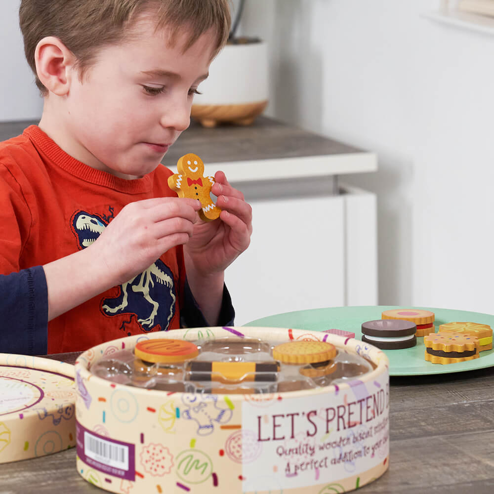  Child putting a toy biscuit on a plate