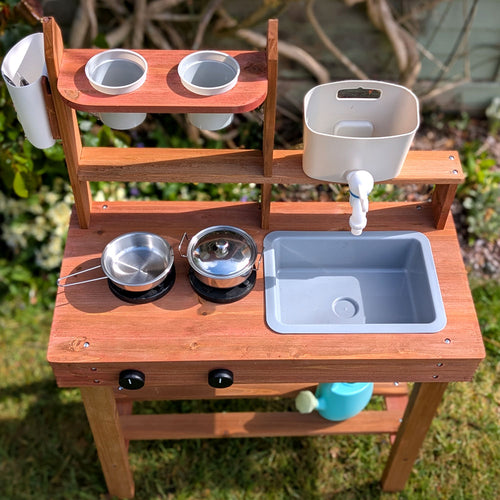 Children's wooden mud kitchen in garden 