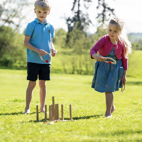 Image of boy and girl taking turns to throw Quoits on the board on lawn