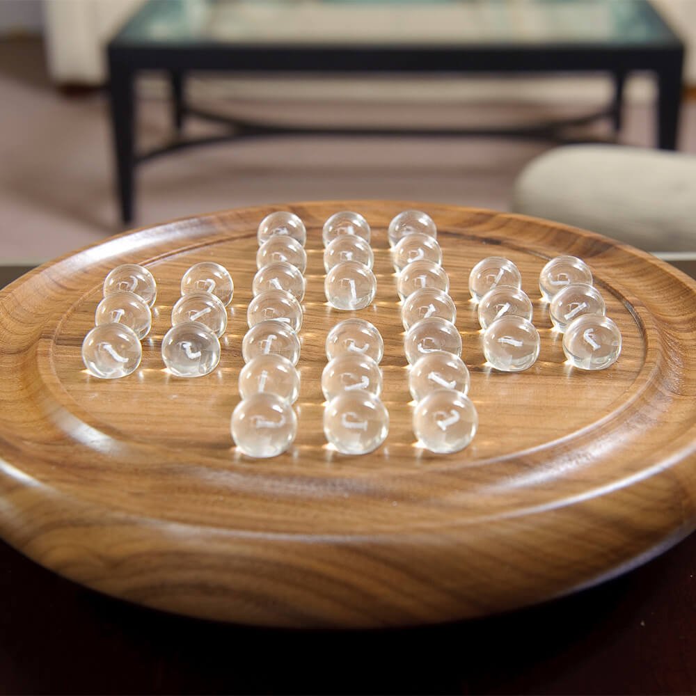  a lifestyle image of the brown solitaire board with clear balls. 